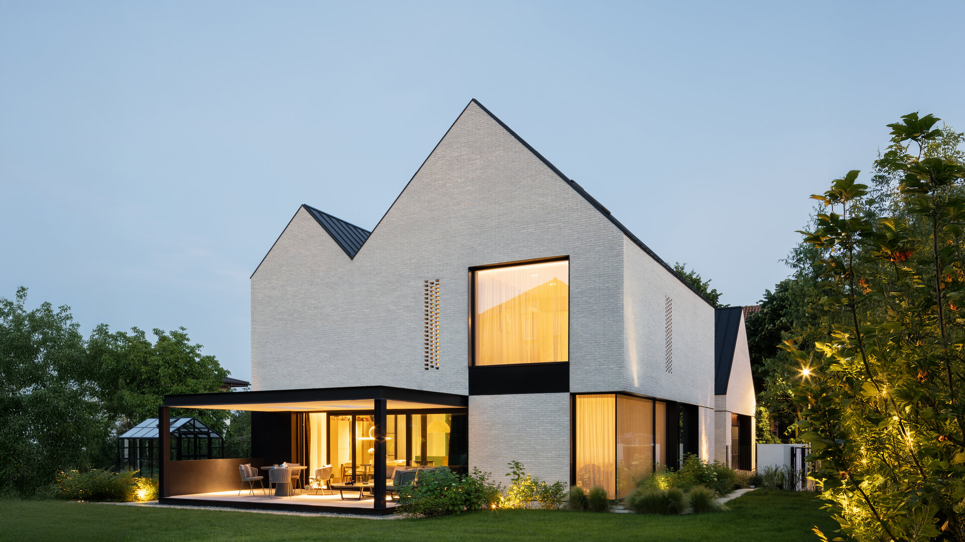 Accente proaspete de verde, într-o locuință care reinterpretează forma clasică a caselor