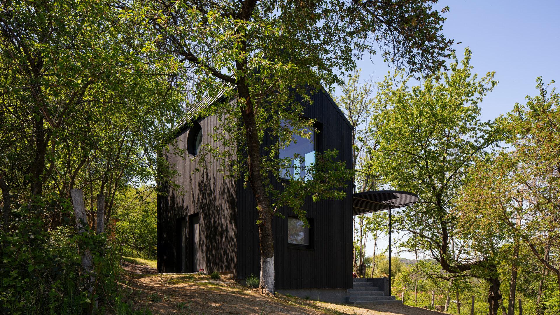 Minimalism în negru și materiale naturale într-o casă de vacanță, în context rural
